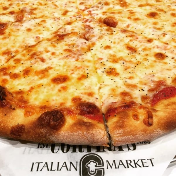 Close-up of a freshly baked cheese pizza from Cortina's Italian Market, with a crispy crust.