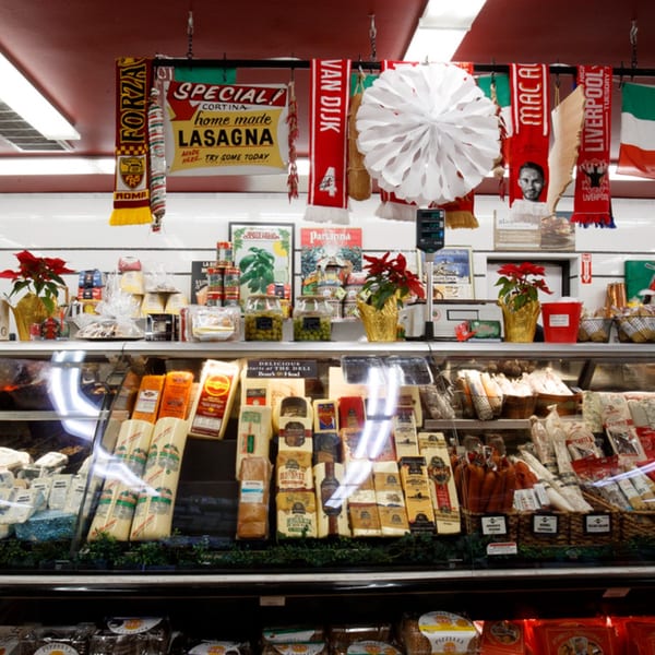 A deli counter at Cortina's Italian Market with various cheeses, meats, and Italian products.