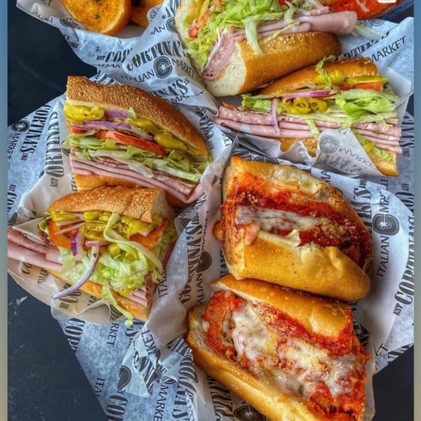 Assortment of Cortina's Italian Market & Pizzeria sandwiches, including cold cuts and meatball subs.