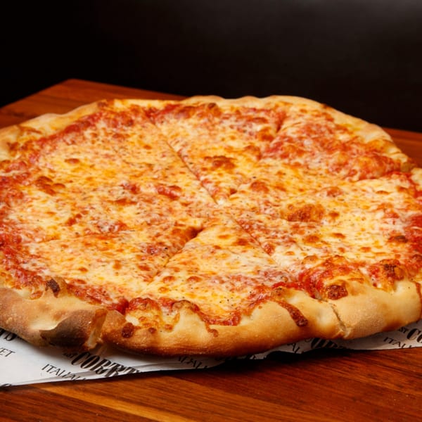 A whole, sliced cheese pizza from Cortina's Italian Market & Pizzeria on a wooden board.