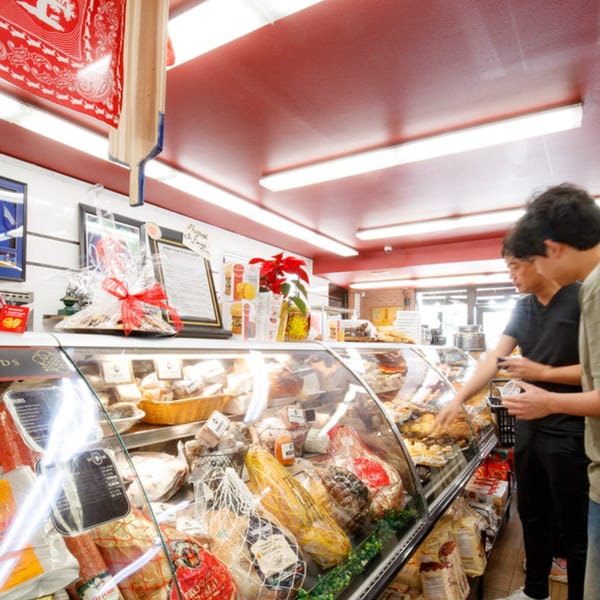 Customers browse a deli case filled with Italian meats and cheeses at Cortina's Italian Market.