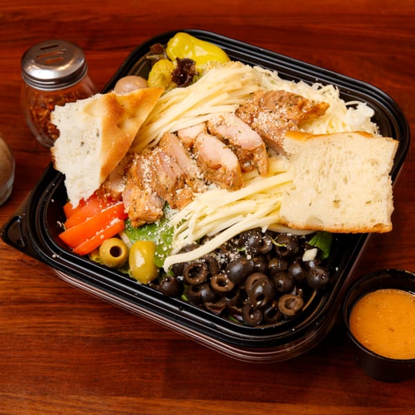 A Cortina's Italian Market & Pizzeria salad with chicken, olives, cheese, and bread.