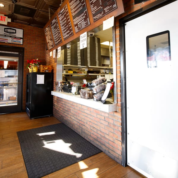 Interior of Cortina's Italian Market & Pizzeria, showing the order counter with menus and pizza boxes.