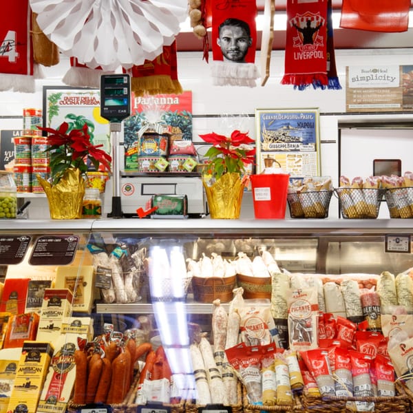 A deli counter at Cortina's Italian Market with various cheeses, meats, and Italian products.